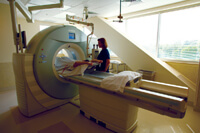 Woman conducting a CT scan on a patient