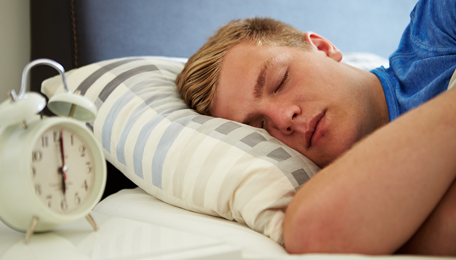 Teen asleep in bed.