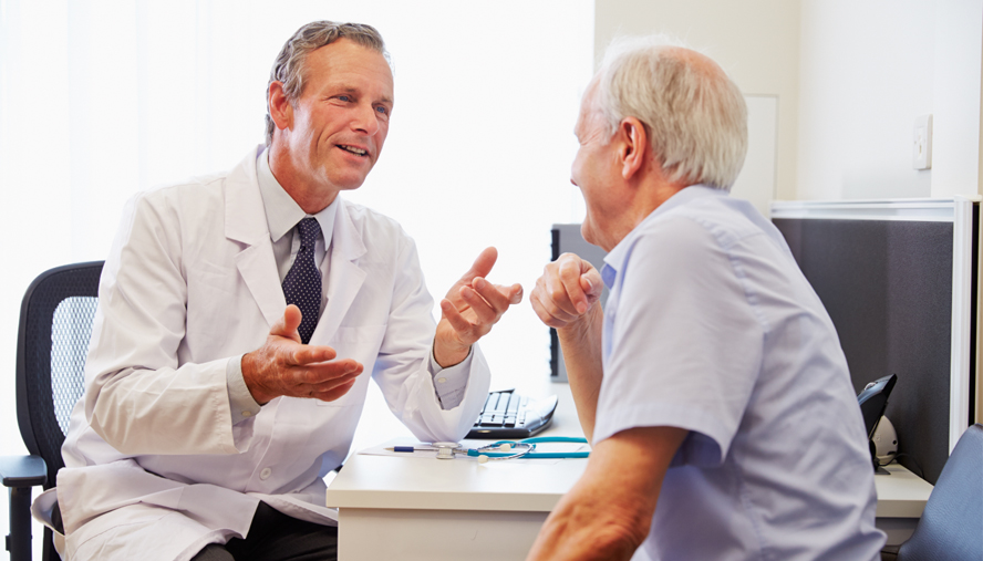 Doctor speaking with elderly male patient.