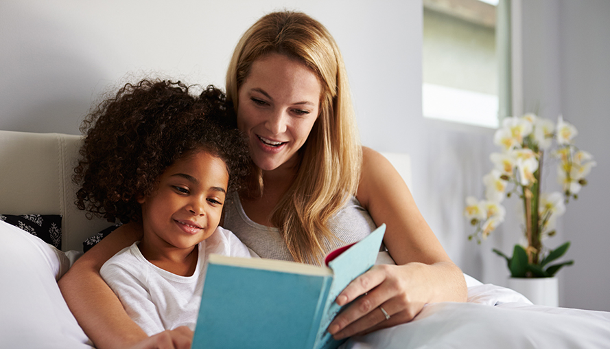 Mother reading a bedtime story to her daughter