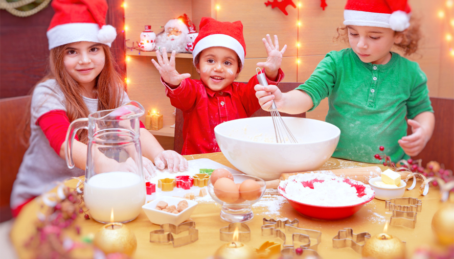 Children in santa hats making cookies