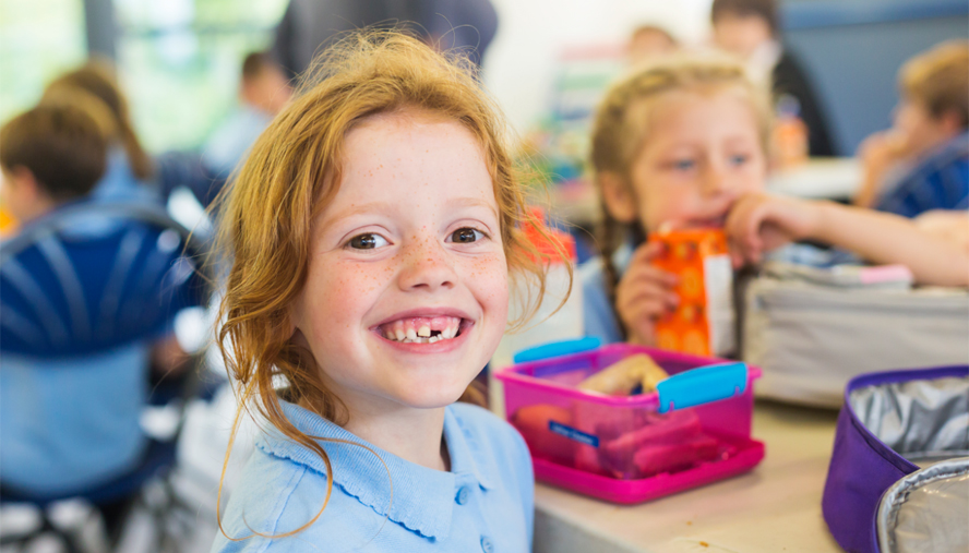 Happy child eating lunch at school