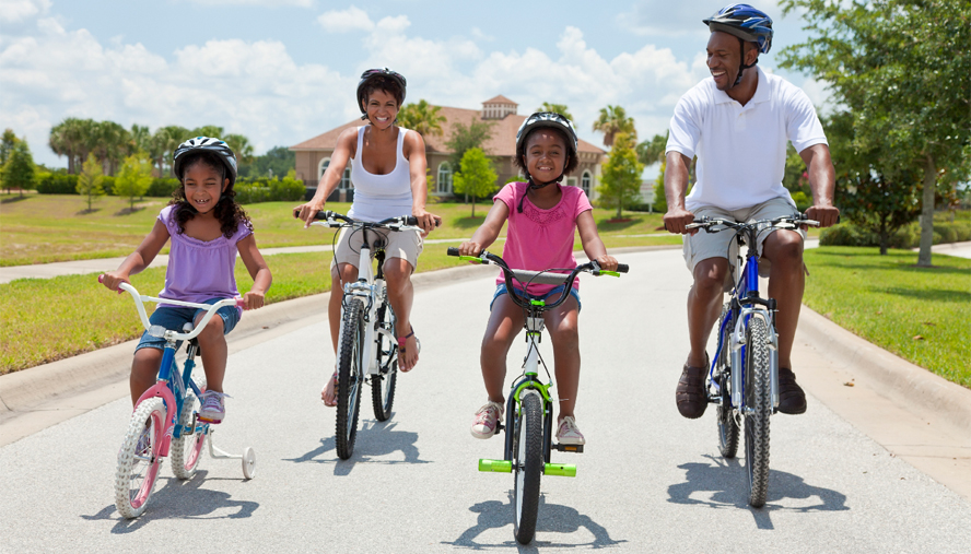 A couple riding bikes with their two children.