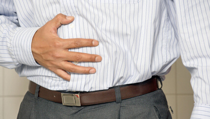 man clutching stomach in distress