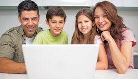 family gathered around a laptop